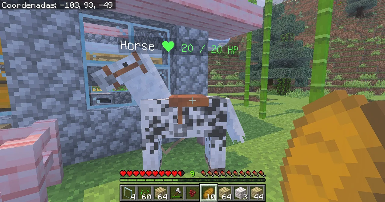 Captura de Minecraft Bedrock: un caballo blanco con manchas negras y montura, y encima la etiqueta Horse con un corazón verde y 20 / 20 HP.